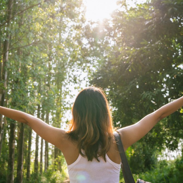 happy-young-asian-woman-traveler-with-backpack-walking-forest
